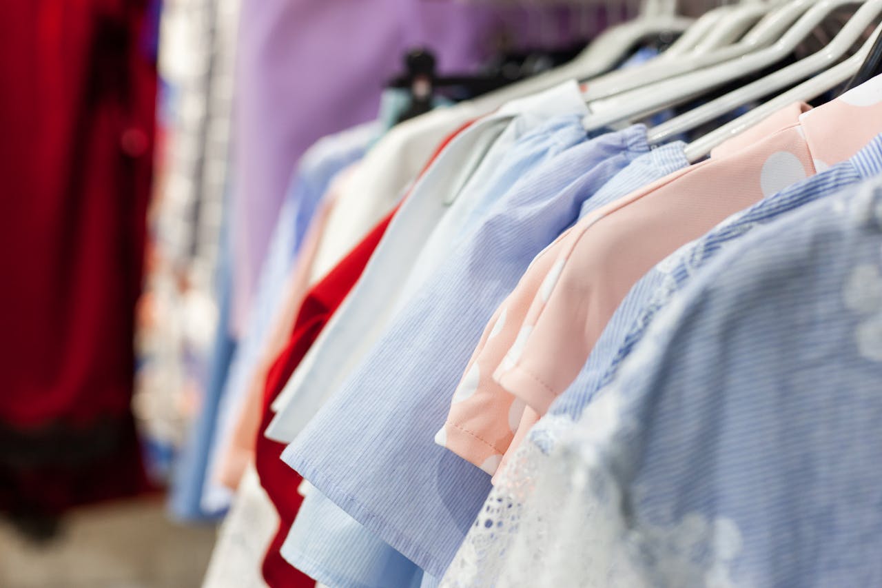 A collection of colorful women's blouses neatly hung on a clothes rack inside a boutique.